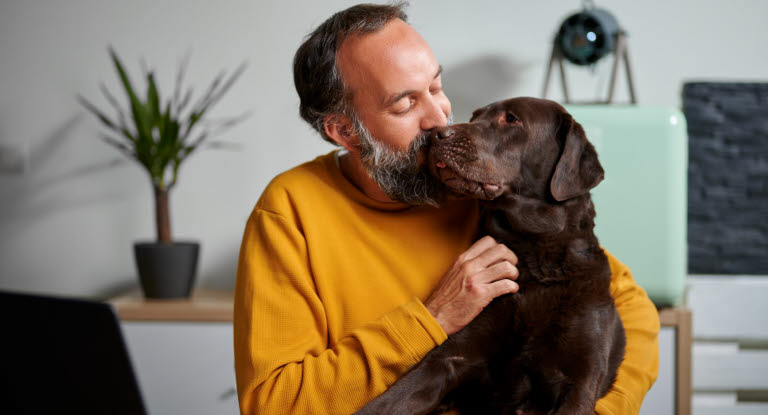 Hund og mann klemmer